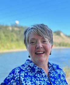 Dawn Bast. AT the river. Laughing.